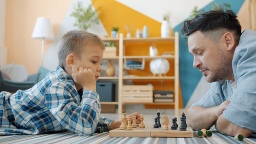 A parent and child playing chess together at home